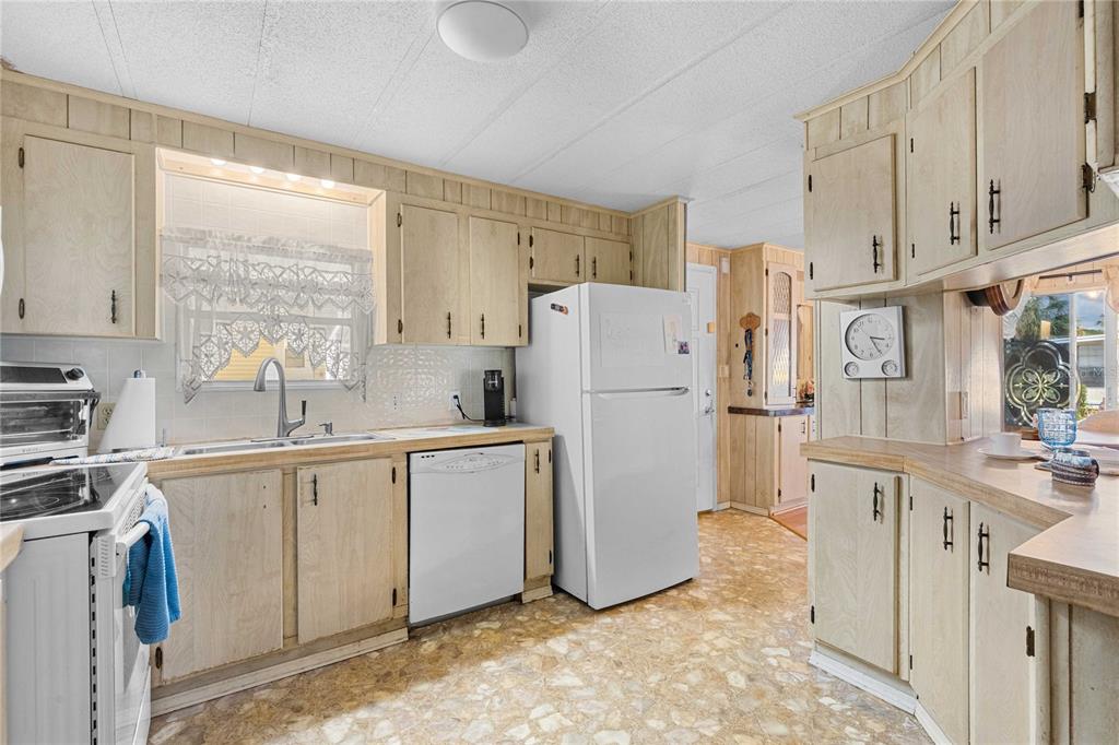 7135 El Dewitt Street Zephyrhills, FL 33541 - Photo 8 of 46 a kitchen with white cabinets and white appliances