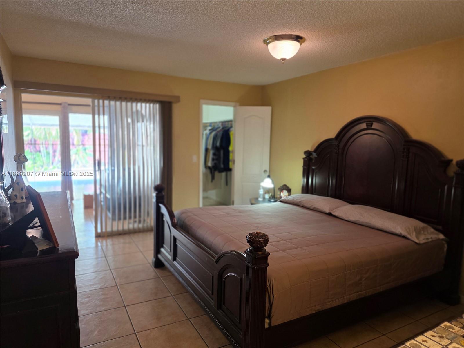 6923 Holly Road Miami Lakes, FL 33014 - Photo 11 of 23 a bed sitting in a bedroom next to a window
