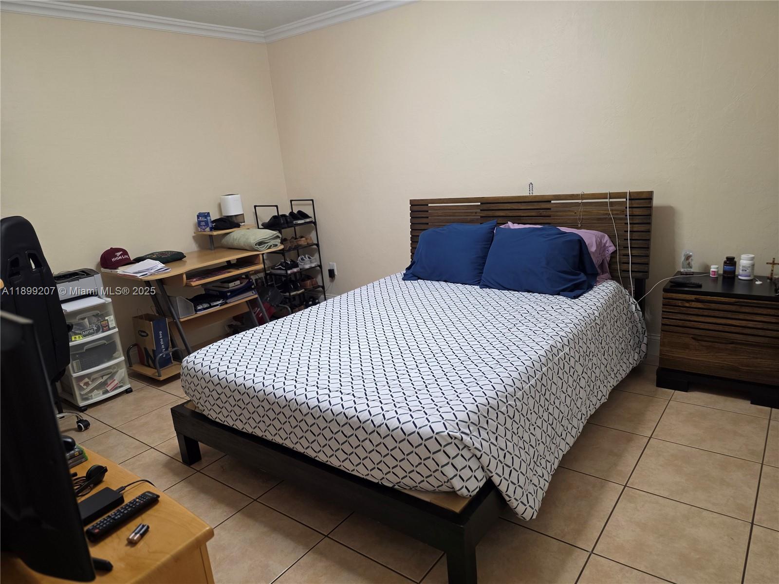 6923 Holly Road Miami Lakes, FL 33014 - Photo 14 of 23 a bed sitting in a bedroom next to a lamp