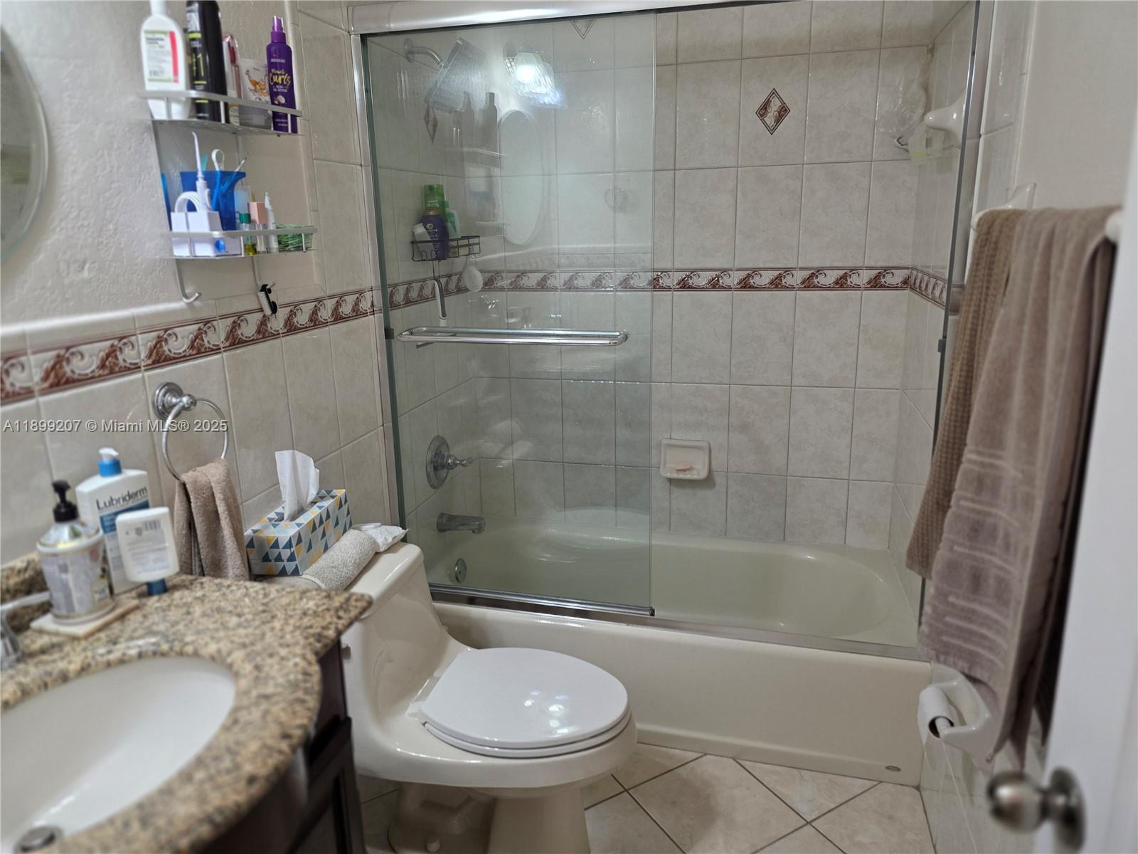 6923 Holly Road Miami Lakes, FL 33014 - Photo 16 of 23 a bathroom with a granite countertop bathtub shower sink vanity and toilet