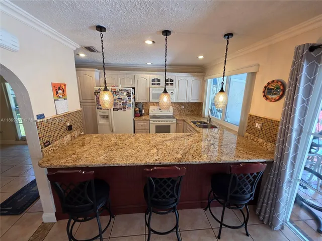 a dining table with chairs and kitchen view