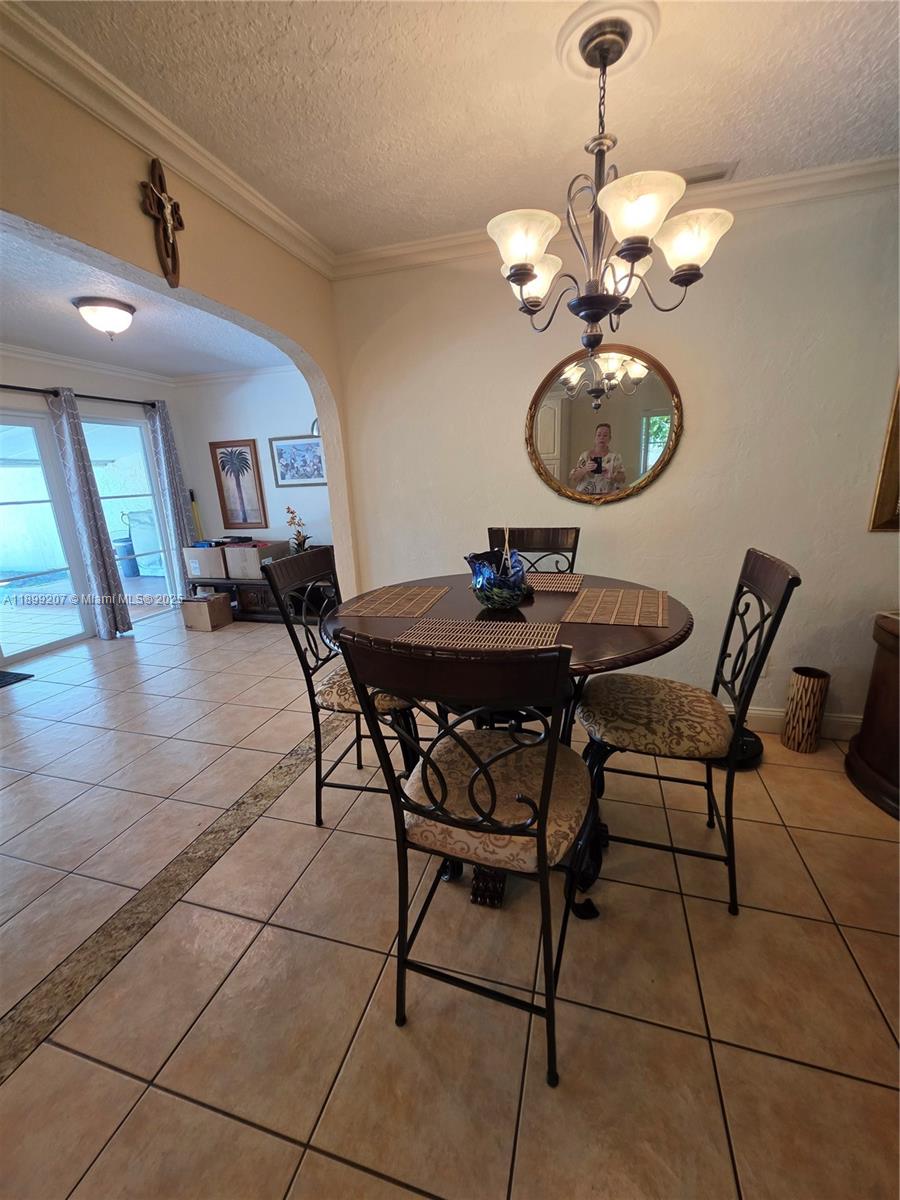 6923 Holly Road Miami Lakes, FL 33014 - Photo 8 of 23 a view of a dining room with furniture and chandelier
