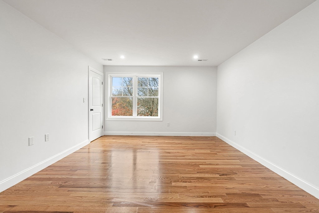 251 Clark Road Lowell, MA 01852 - Photo 25 of 36 a view of an empty room with wooden floor and a window
