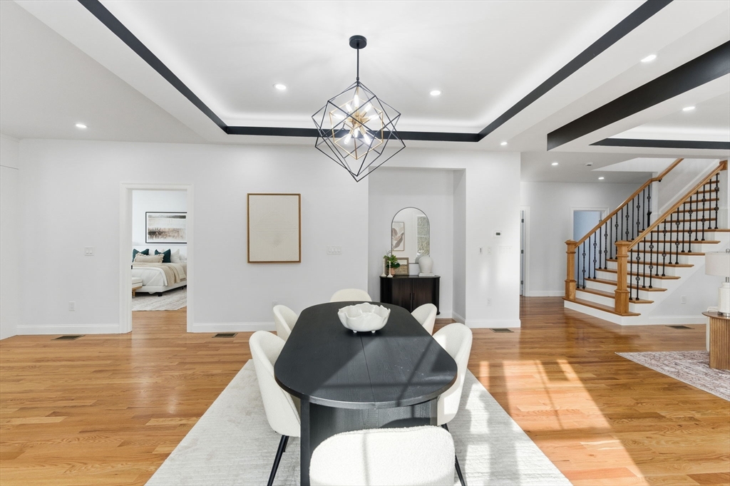 251 Clark Road Lowell, MA 01852 - Photo 7 of 36 a living room with couches a dining table and chairs with wooden floor