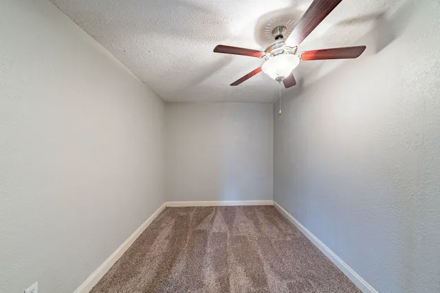 a view of an empty room with a ceiling fan