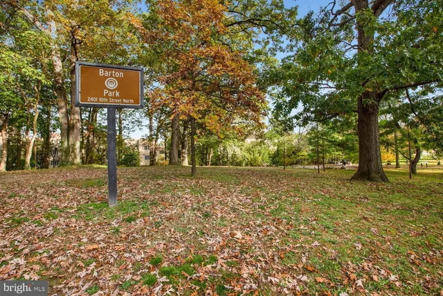 a sign board with tall trees