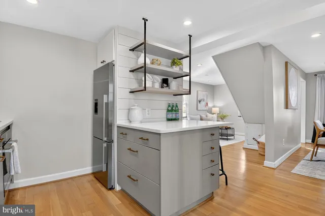 a kitchen with stainless steel appliances a sink cabinets and wooden floor