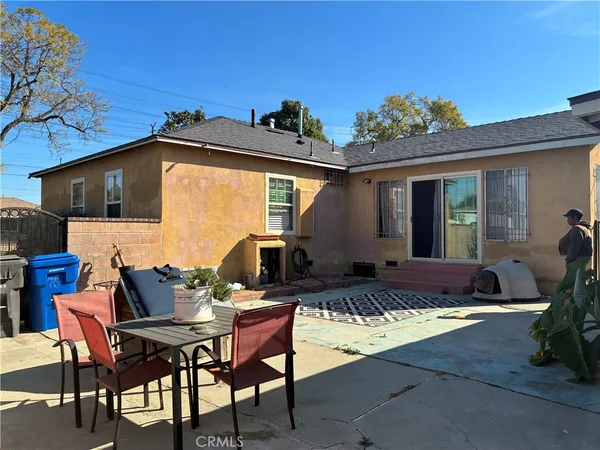 a backyard of a house with fountain table and chairs