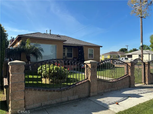 a front view of a house with a yard and potted plants