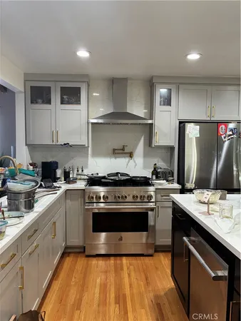 a kitchen with stainless steel appliances granite countertop a sink a stove and a wooden floors