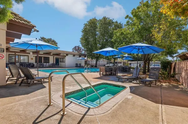 a patio with a table and chairs under an umbrella