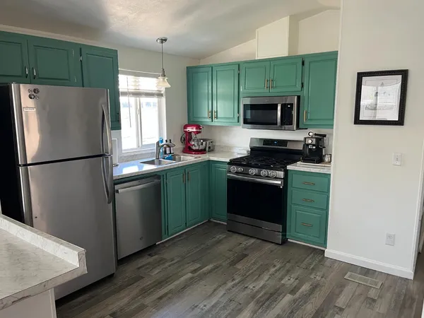 a kitchen with a refrigerator and a stove top oven