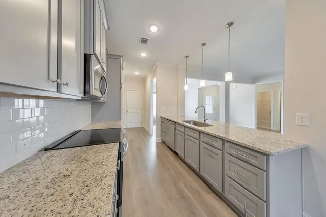a large kitchen with kitchen island a sink stainless steel appliances and cabinets