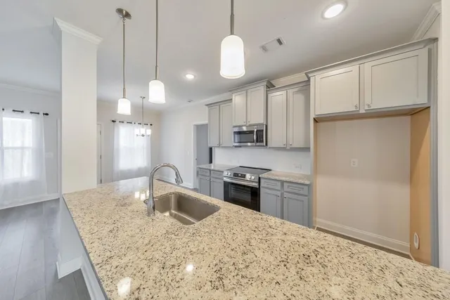 a kitchen with kitchen island white cabinets and stainless steel appliances