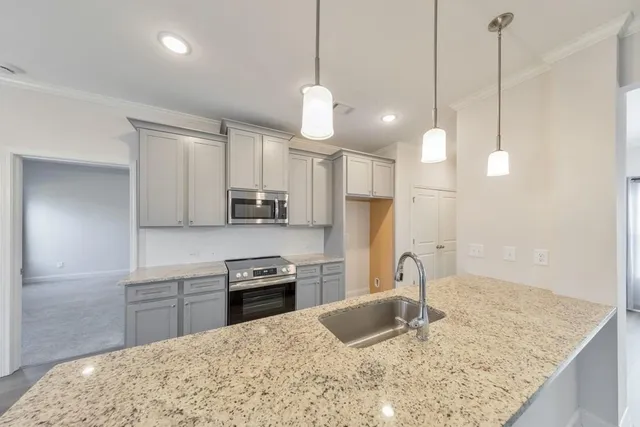 a kitchen with stainless steel appliances granite countertop a sink a stove a refrigerator and island