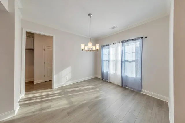a view of a livingroom with a chandelier fan and windows