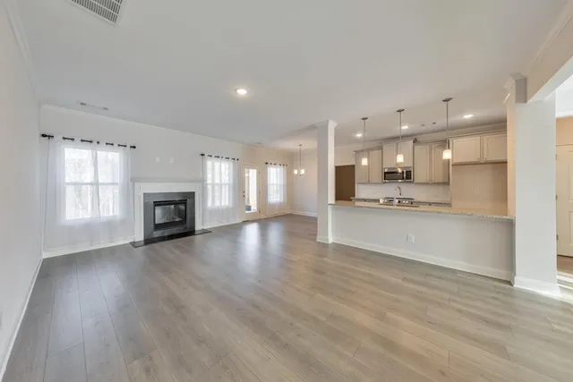 a view of kitchen with kitchen island wooden floor appliances and cabinets