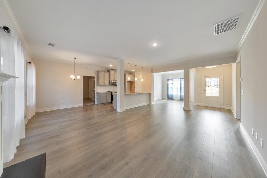 276 Brookstone Trail Dawsonville, GA 30534 - Photo 8 of 44 a view of an empty room and a kitchen with wooden floor
