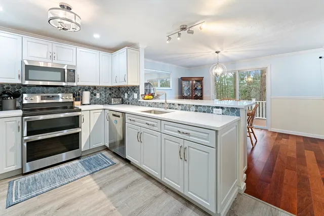 a kitchen with granite countertop a sink stainless steel appliances and cabinets