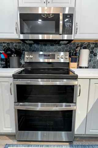 a stove top oven sitting inside of a kitchen