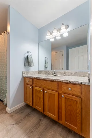 a bathroom with a granite countertop double vanity sink and mirror
