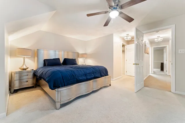 a spacious bedroom with a bed and a chandelier