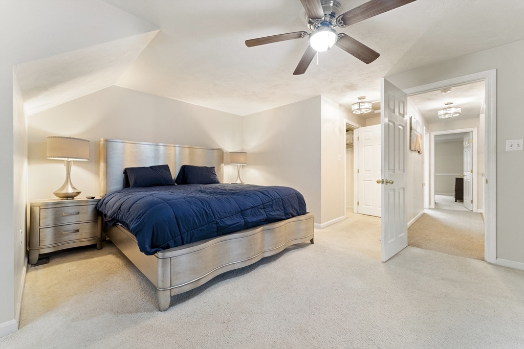 7 Millers Way, Unit C Sutton, MA 01590 - Photo 23 of 28 a spacious bedroom with a bed and a chandelier