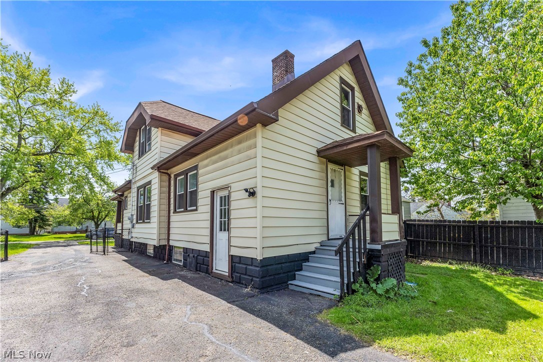 18123 McCracken Road Maple Heights, OH 44137 - Photo 26 of 27 Exterior featuring light-colored siding with dark trim, a covered porch with dark columns, and a paved driveway