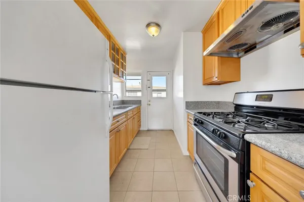 a kitchen with stainless steel appliances granite countertop a stove a refrigerator and a microwave