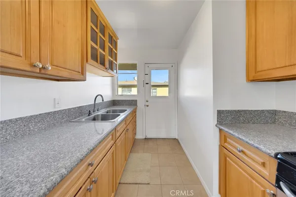 a kitchen with granite countertop a sink a stove and cabinets