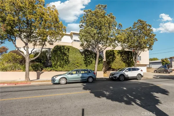 a view of a cars parked on the side of a street