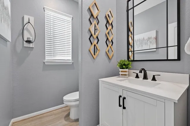a bathroom with a toilet sink and mirror