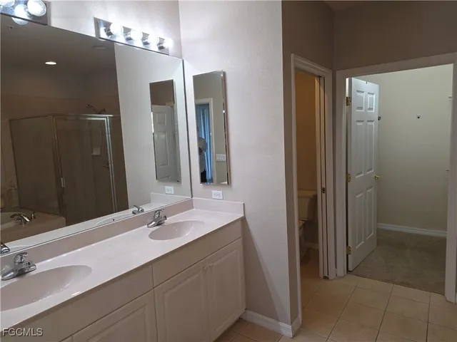 a bathroom with a double vanity sink mirror and shower