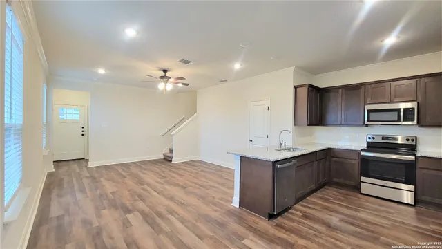 a kitchen with stainless steel appliances granite countertop a sink and a stove top oven