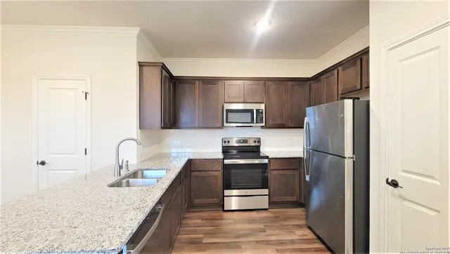 a kitchen with stainless steel appliances granite countertop a refrigerator sink and stove