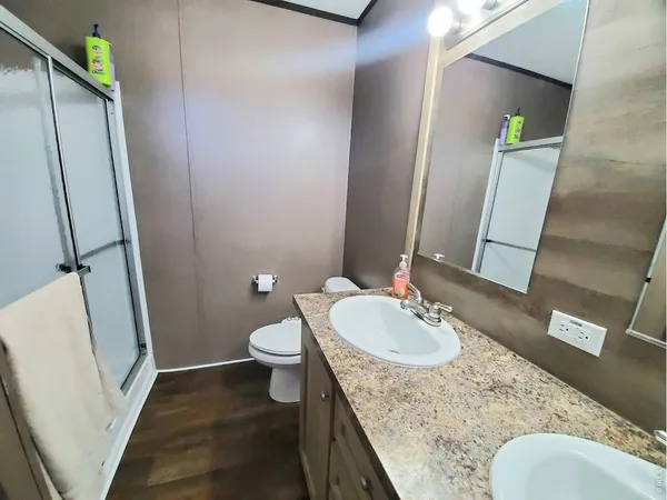 a bathroom with a granite countertop sink a mirror and a toilet