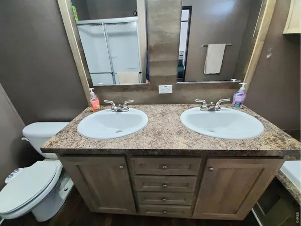 a bathroom with a granite countertop toilet sink and mirror