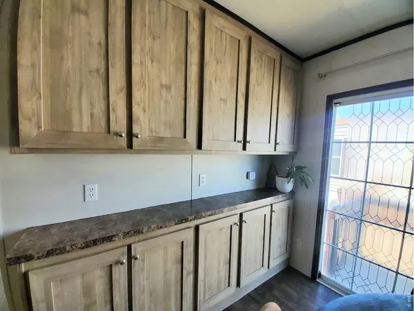 a kitchen with stainless steel appliances granite countertop white cabinets and window