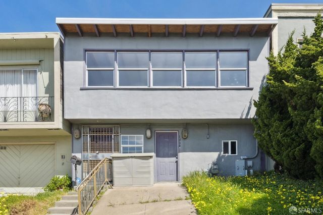 a front view of a house with a yard and outdoor seating