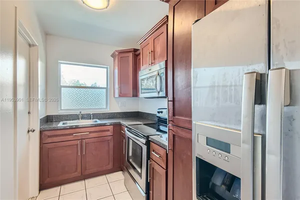 a kitchen with granite countertop cabinets stainless steel appliances and wooden cabinets