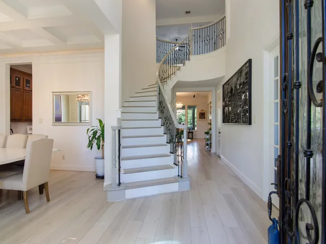 a view of a hallway with wooden floor windows a fireplace and livingroom with wooden floor