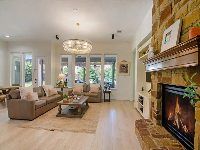 a living room with furniture a fireplace and a chandelier