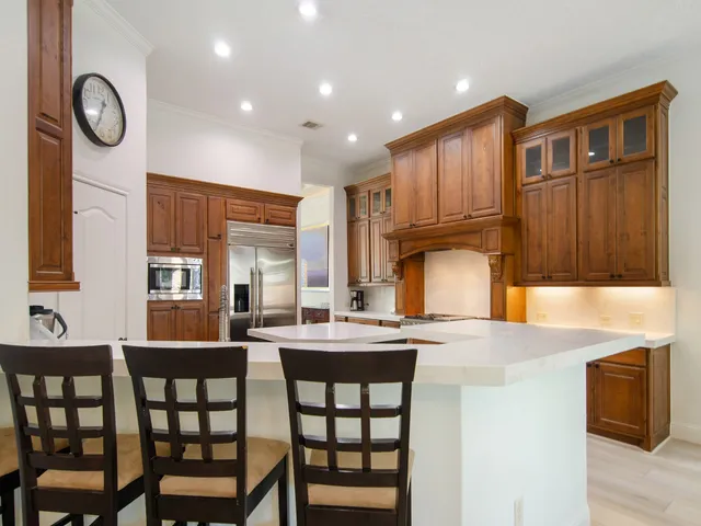 a kitchen with stainless steel appliances granite countertop a stove a sink and a refrigerator