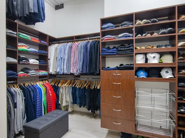 a view of walk in closet with clothes and shoes