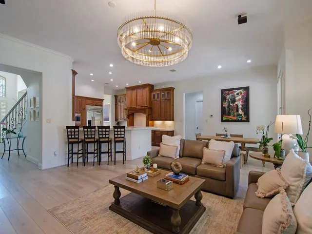 a living room with furniture kitchen view and a wooden floor