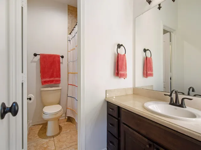 a bathroom with a sink a toilet and a mirror