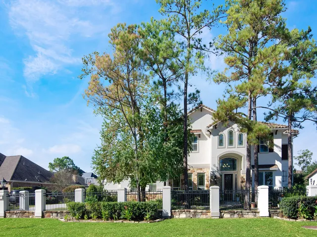 a view of a white house with a big yard and large trees