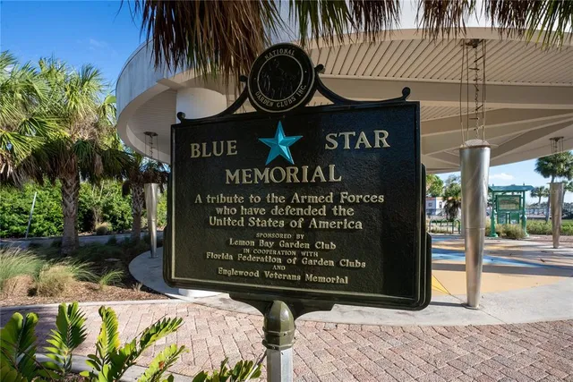a front view of multi story residential apartment building with yard and seating area