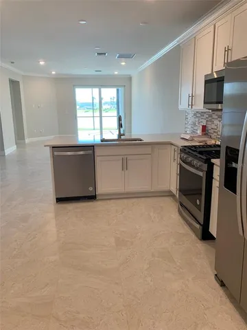 a kitchen with granite countertop a stove a sink and a microwave