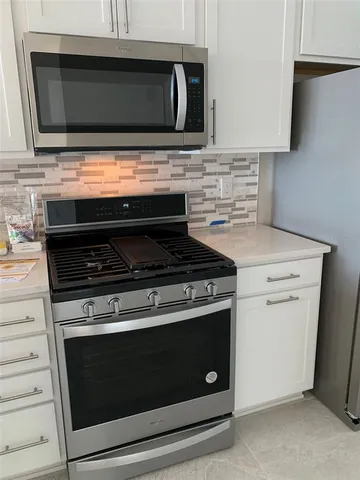 a stove top oven sitting inside of a kitchen